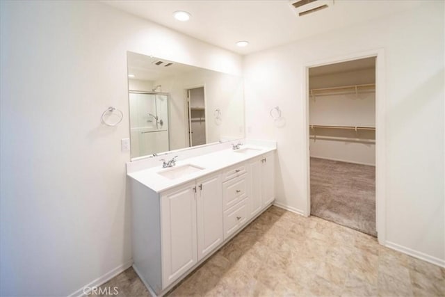 3409 Spring Wheat St, Perris, CA 92570 - bathroom featuring a spacious closet, a stall shower, double vanity, baseboards, and recessed lighting