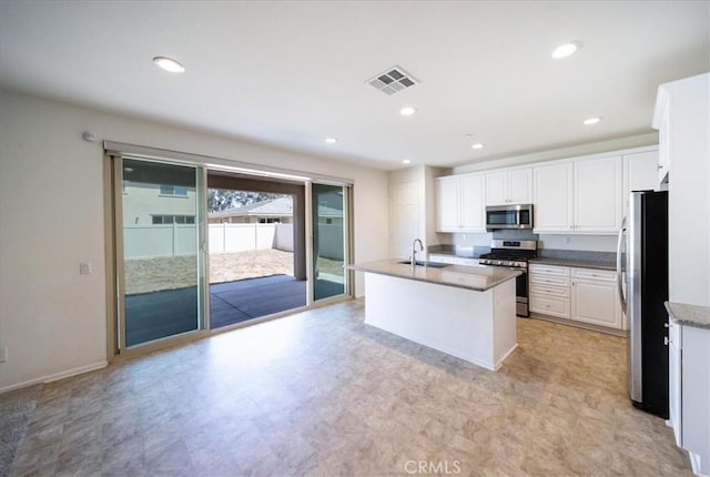 3409 Spring Wheat St, Perris, CA 92570 - kitchen featuring stainless steel appliances, a sink, white cabinetry, a kitchen island with sink, and light floors