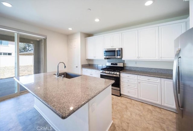 3409 Spring Wheat St, Perris, CA 92570 - kitchen featuring stainless steel appliances, a sink, white cabinets, dark stone counters, and recessed lighting