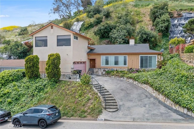 5134 Veronica St, Los Angeles, CA 90008 - split level home with a garage, fence, asphalt driveway, and stone siding