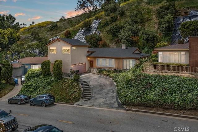 5134 Veronica St, Los Angeles, CA 90008 - split level home featuring a garage, driveway, and stucco siding