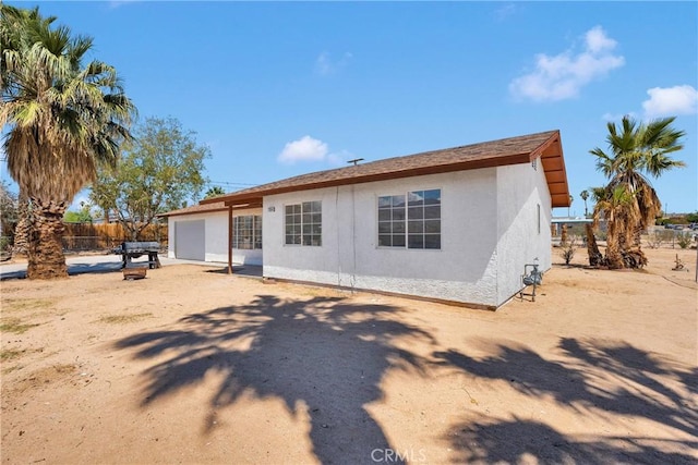 71854 El Paseo Dr Unit 29, Palms, CA 92277 - back of house featuring stucco siding, a garage, and fence