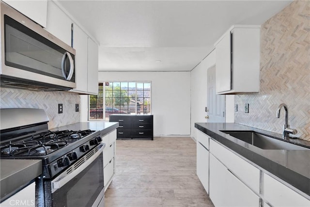 71854 El Paseo Dr Unit 29, Palms, CA 92277 - kitchen featuring appliances with stainless steel finishes, a sink, white cabinetry, and backsplash