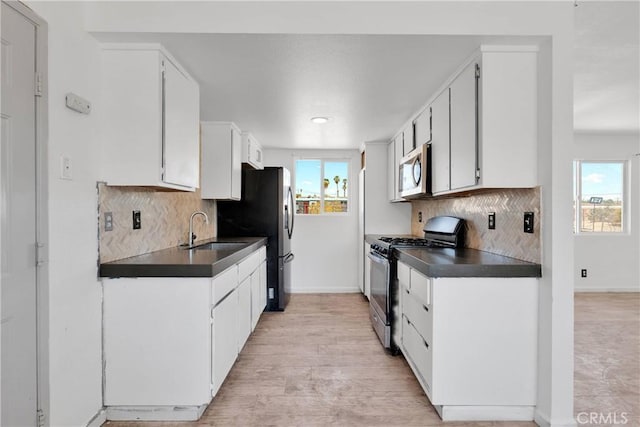 71854 El Paseo Dr Unit 29, Palms, CA 92277 - kitchen with appliances with stainless steel finishes, a sink, dark countertops, baseboards, and decorative backsplash