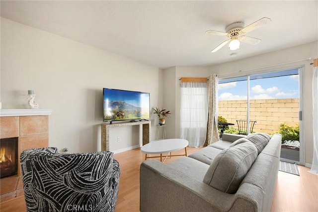 27559 Avenida Interno, Menifee, CA 92585 - living area with light wood-style flooring, ceiling fan, a tile fireplace, and baseboards