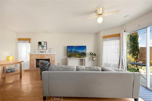 27559 Avenida Interno, Menifee, CA 92585 - living area featuring wood finished floors, a ceiling fan, a tile fireplace, and baseboards