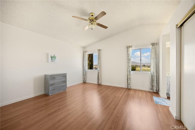 27559 Avenida Interno, Menifee, CA 92585 - unfurnished bedroom with multiple windows, a textured ceiling, wood finished floors, lofted ceiling, and ceiling fan
