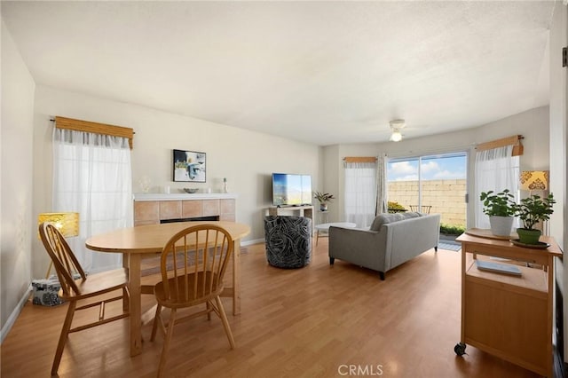 27559 Avenida Interno, Menifee, CA 92585 - dining space with light wood-style floors, a tile fireplace, a ceiling fan, and baseboards