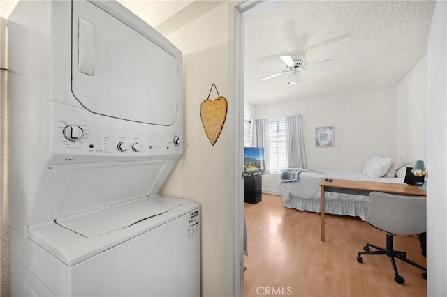 27559 Avenida Interno, Menifee, CA 92585 - laundry area featuring estacked washer and dryer, light wood-style flooring, a textured ceiling, and a ceiling fan