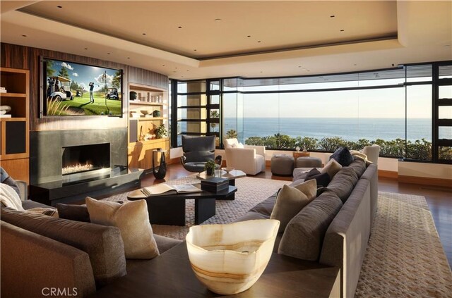 2526 Riviera Dr, Laguna Beach, CA 92651 - living room featuring a tray ceiling, a premium fireplace, wood finished floors, and a water view