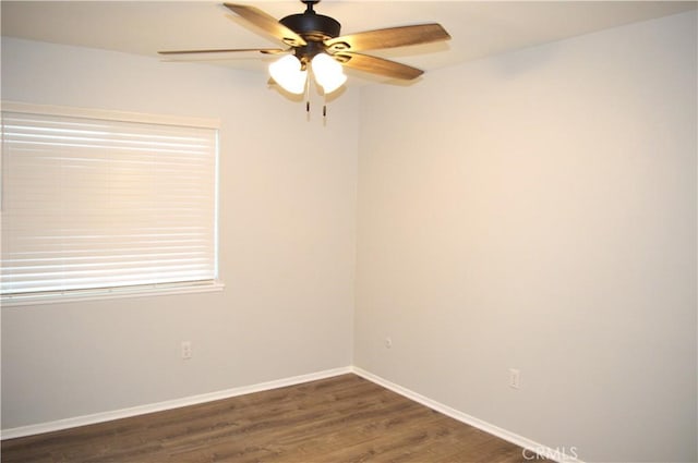 empty room with dark wood-style flooring, ceiling fan, and baseboards