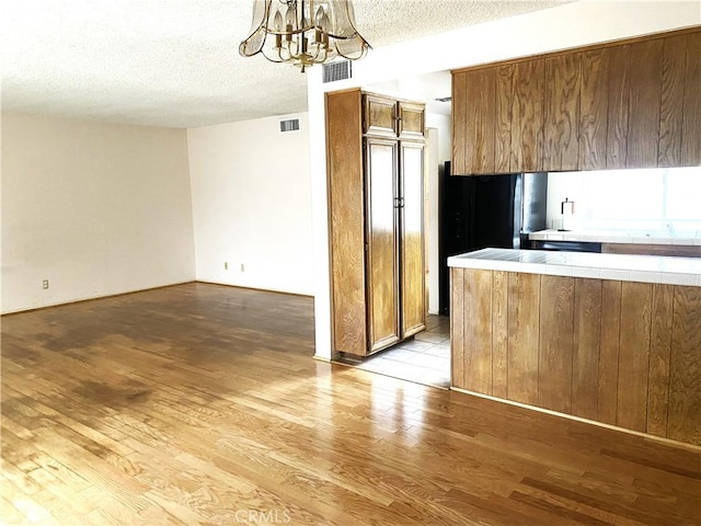 1740 Silver Maple Dr, La Habra, CA 90631 - kitchen with tile countertops, hardwood / wood-style flooring, a chandelier, brown cabinets, and a textured ceiling