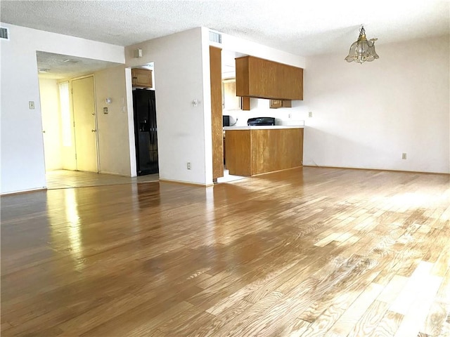 1740 Silver Maple Dr, La Habra, CA 90631 - unfurnished living room with light wood finished floors, a chandelier, and a textured ceiling