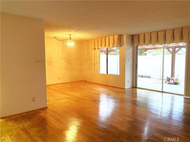 1740 Silver Maple Dr, La Habra, CA 90631 - spare room with a textured ceiling, hardwood / wood-style flooring, and a chandelier
