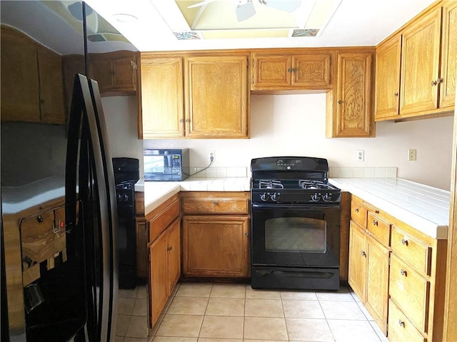 1740 Silver Maple Dr, La Habra, CA 90631 - kitchen featuring black appliances, tile countertops, light tile patterned floors, a ceiling fan, and brown cabinets