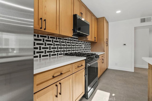 2835 S Fairview St Unit C, Santa Ana, CA 92704 - kitchen with gas range oven, tasteful backsplash, freestanding refrigerator, light countertops, and baseboards