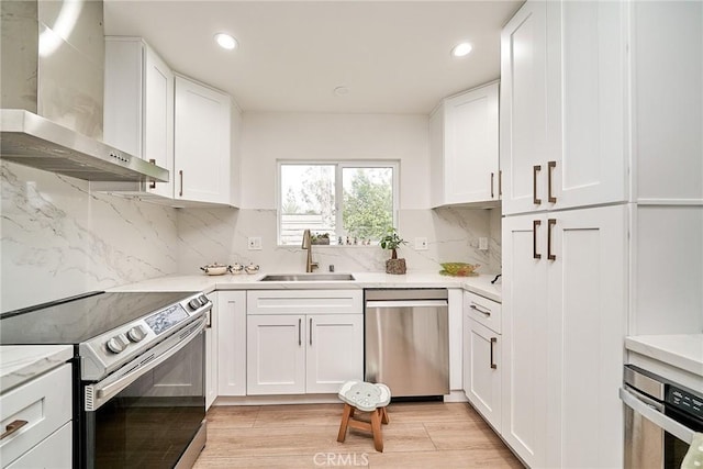 3004 Via Buena Vis Unit C, Laguna Woods, CA 92637 - kitchen featuring wall chimney exhaust hood, stainless steel appliances, a sink, recessed lighting, and white cabinetry