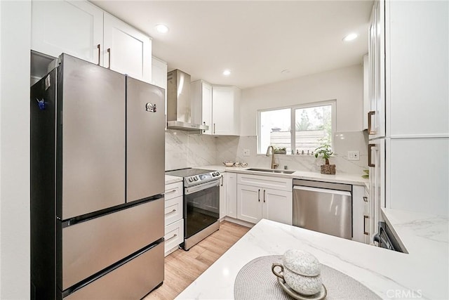 3004 Via Buena Vis Unit C, Laguna Woods, CA 92637 - kitchen with appliances with stainless steel finishes, wall chimney range hood, a sink, light stone countertops, and white cabinetry