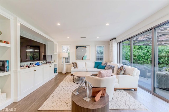 living area with light wood finished floors, recessed lighting, and baseboards
