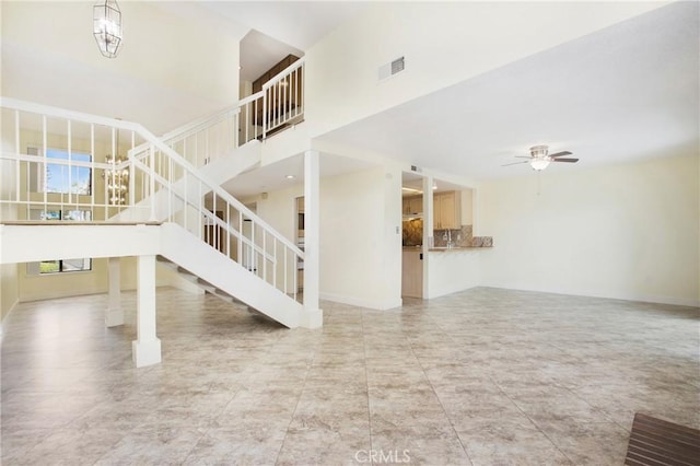 611 Colonial Cir, Fullerton, CA 92835 - unfurnished living room featuring stairway, a ceiling fan, and a towering ceiling