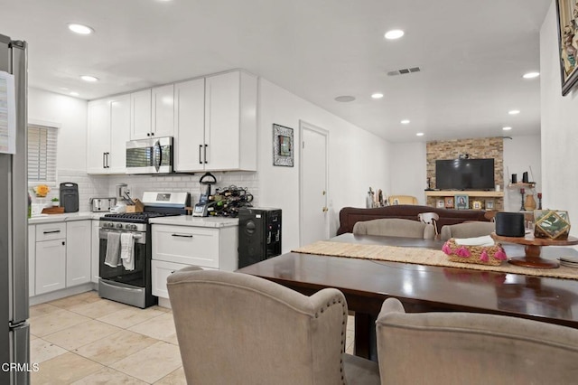 4241 Hamilton Ave, Oxnard, CA 93033 - kitchen with stainless steel appliances, white cabinets, decorative backsplash, light tile patterned floors, and recessed lighting