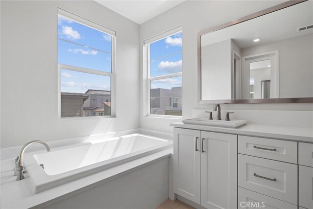 bathroom with vanity and a bath