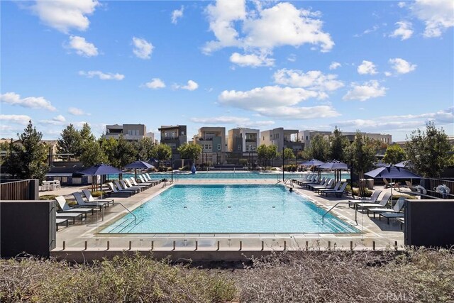 community pool with fence and a patio