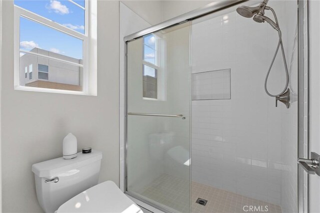bathroom featuring a shower stall and toilet