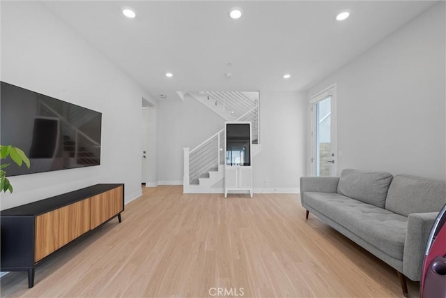 living room with stairs, light wood-style floors, recessed lighting, and baseboards