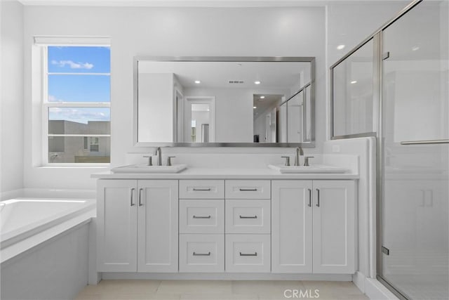 bathroom with a shower stall, a bath, double vanity, and tile patterned floors