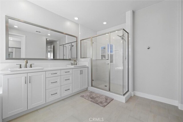 bathroom with a stall shower, double vanity, recessed lighting, and baseboards