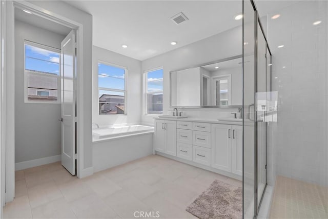 full bathroom with a stall shower, double vanity, a bath, baseboards, and recessed lighting