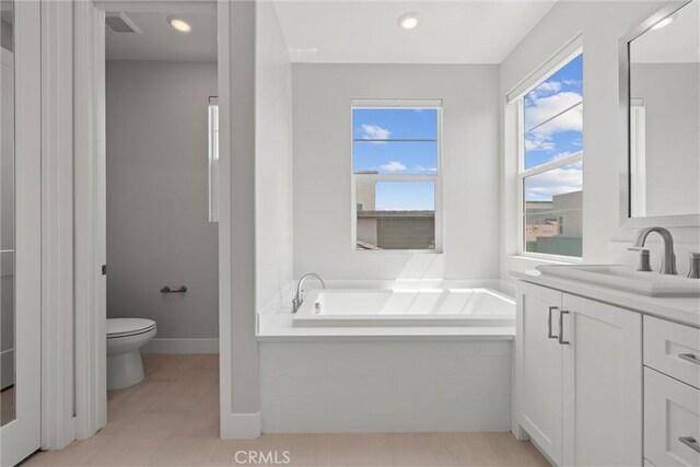 bathroom featuring toilet, a bath, vanity, and tile patterned flooring
