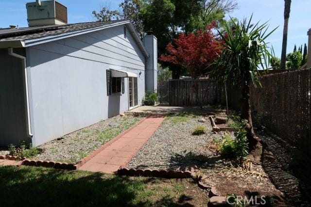 819 Sherwood Way, Willows, CA 95988 - view of side of home with fence and a chimney