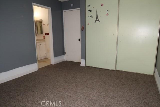 819 Sherwood Way, Willows, CA 95988 - unfurnished bedroom with dark carpet, a closet, ensuite bath, and baseboards