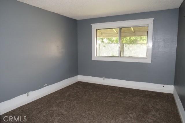 819 Sherwood Way, Willows, CA 95988 - empty room with dark colored carpet and baseboards