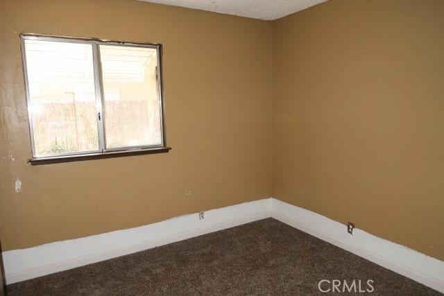 819 Sherwood Way, Willows, CA 95988 - empty room featuring dark carpet and baseboards