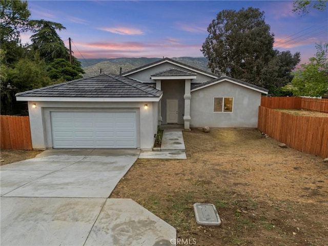 230 E Hoffer St, Banning, CA 92220 - ranch-style house with fence, an attached garage, concrete driveway, and stucco siding
