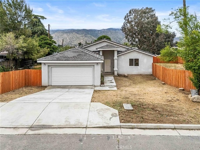230 E Hoffer St, Banning, CA 92220 - ranch-style house with an attached garage, a mountain view, concrete driveway, and stucco siding
