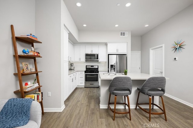 204 Alienta Ln, Rancho Mission Viejo, CA 92694 - kitchen with appliances with stainless steel finishes, dark wood-style floors, a center island with sink, decorative backsplash, and light countertops