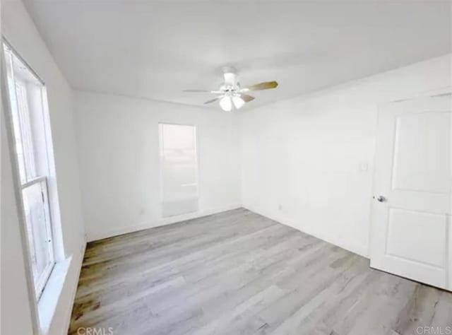 unfurnished room featuring ceiling fan, plenty of natural light, and wood finished floors