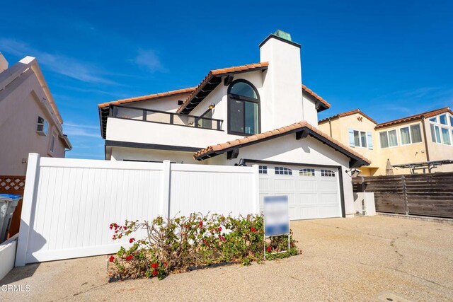 5304 Whitecap St, Oxnard, CA 93035 - mediterranean / spanish-style home featuring a balcony, a chimney, a garage, concrete driveway, and a tile roof