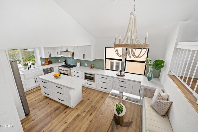 5304 Whitecap St, Oxnard, CA 93035 - kitchen with appliances with stainless steel finishes, under cabinet range hood, high vaulted ceiling, light wood-style floors, and light countertops