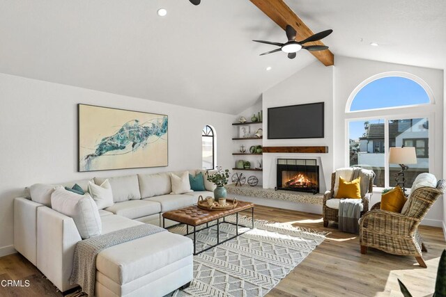 5304 Whitecap St, Oxnard, CA 93035 - living room featuring beam ceiling, a lit fireplace, ceiling fan, wood finished floors, and high vaulted ceiling