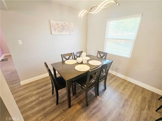 dining space with baseboards and light wood-style flooring