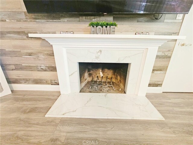 detailed view of wood finished floors and a premium fireplace