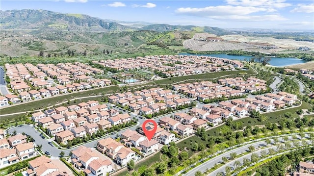 aerial view of property and surrounding area with nearby suburban area and a water and mountain view