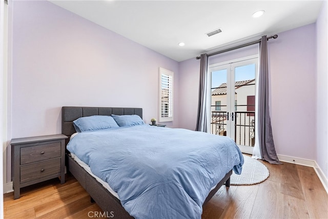 bedroom with light wood-type flooring, access to exterior, baseboards, and recessed lighting