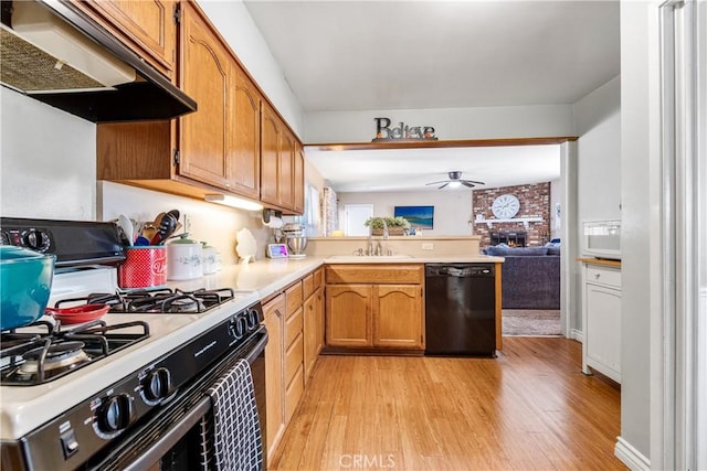 4702 Castana Ave, Lakewood, CA 90712 - kitchen with gas range, black dishwasher, wall chimney exhaust hood, a ceiling fan, and light wood finished floors