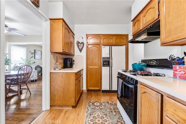 4702 Castana Ave, Lakewood, CA 90712 - kitchen featuring range with gas cooktop, white refrigerator with ice dispenser, under cabinet range hood, light wood finished floors, and light countertops
